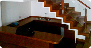 Enchape de escalera de primer a segundo piso en madera shihuahuaco, tiene pasamanos y alguno balaustres en madera, con barandas de vidrio templado. Acabado con Varathane al agua  semi mate